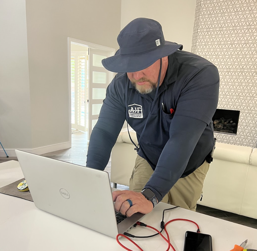 An AJF inspector going through the results of builder warranties and home inspections on his computer in the kitchen