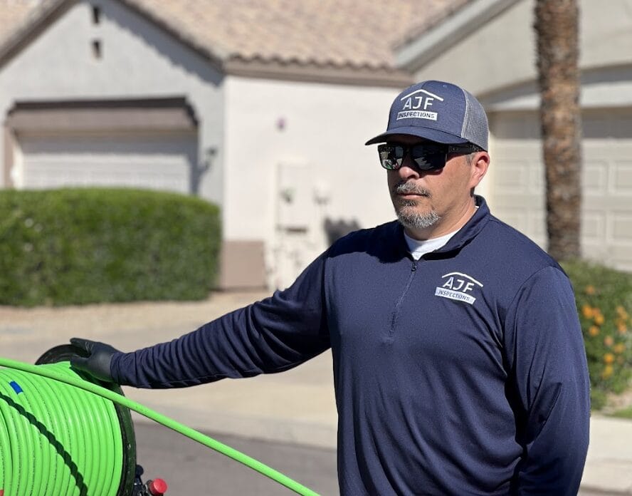 AJF Inspections inspector in branded uniform preparing equipment for a home inspection in Phoenix